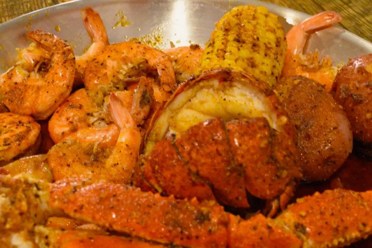 Spiced seafood platter snow crab lobster tail shrimp corn potato at Red Crab Juicy Seafood, a Seafood Restaurant in Brooklyn