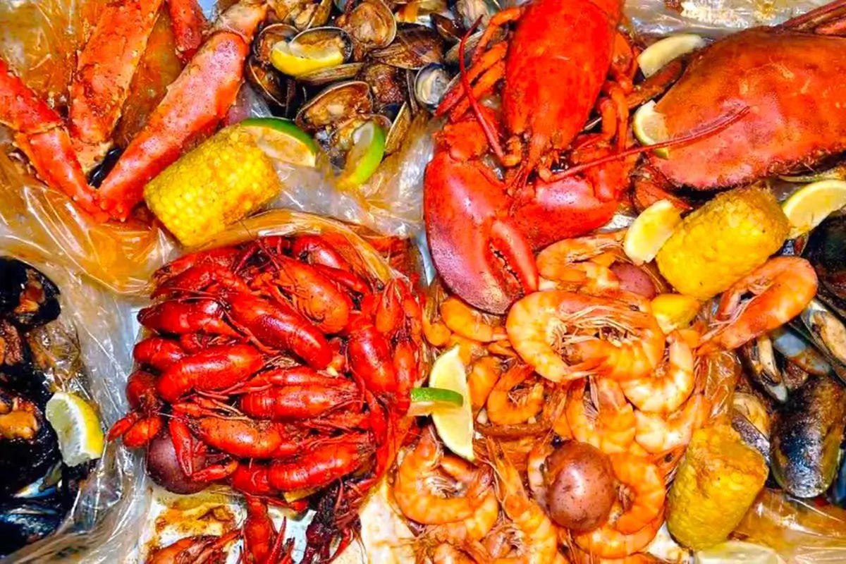 Loaded seafood boil platter lobster crawfish shrimp clams corn lemon at Red Crab Juicy Seafood, a Seafood Restaurant in Brooklyn
